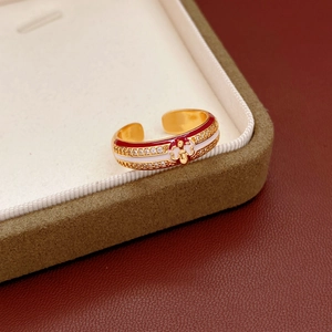 Detail of 18k gold plated open ring with red white enamel and sparkling zircon accents