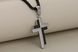 Close-up of minimalist black and white spliced stainless steel cross pendant necklace