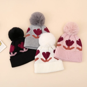 Thick knit baby winter hats with floral patterns and fluffy faux fur pom-poms in four colors