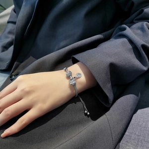 Close-up of silver zircon heart charm bracelet on wrist with adjustable sliding clasp