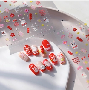 Detail of red rabbit nail art stickers with festive Chinese motifs and 3D relief texture