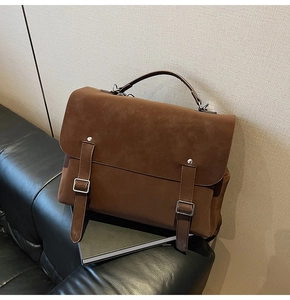 Detail of vintage brown suede leather backpack with silver buckles and a top handle