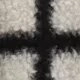 Close-up of black and white plaid boucle fabric texture with soft plush faux fur material