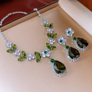 Detail of vintage silver jewelry set with green teardrop gemstones and cubic zirconia