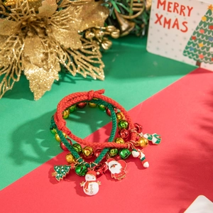 Detailed close-up of Christmas charm bracelet with bells and Santa pendants on festive cards