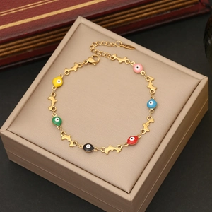 Golden bracelet featuring colorful devil eye beads and dolphin links on display box