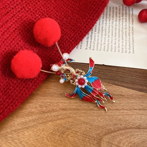Macro shot of festive hair clip with red fur balls and pearl inlay details