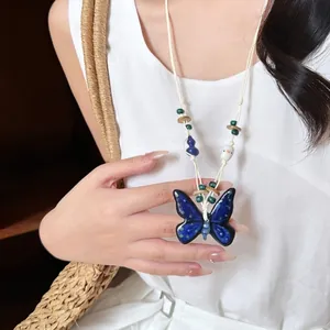 Bohemian style blue ceramic butterfly pendant necklace with handwoven cream rope cord