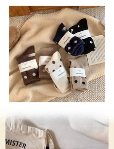 Détail de six paires de chaussettes à pois en laine aux couleurs variées avec emballage