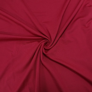 Detailed view of the dark red pleated fabric texture and soft knitted material of the dress