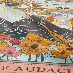 Close-up of bohemian tarot tapestry fabric showing sun, moon, and skull pattern texture