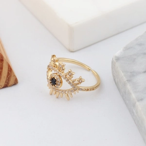 Macro detail of gold evil eye snake ring with white zircon and black crystal stone