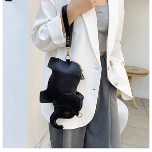 Chic black elephant shaped crossbody bag styled with a white blazer and grey trousers