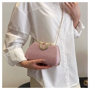 Detailed view of a pink sequin evening bag featuring a gold chain strap and buckle