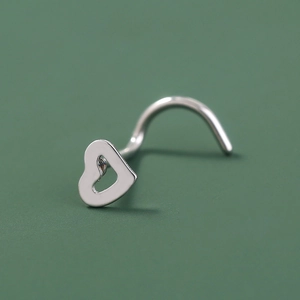 Macro shot of L-shaped silver nose stud featuring a hollow heart design in polished steel