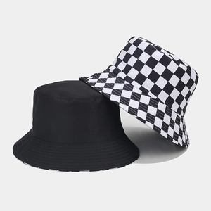 Close-up of double-sided bucket hat with black and white checkerboard pattern and solid cotton
