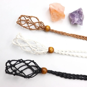 Detail of handmade woven stone cage pendant rope in black, brown, and white colors