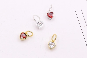 Macro shot of S925 silver and gold heart pendants with red and white zircons for DIY