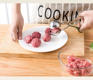 Close-up of stainless steel meat baller scoop making fresh meatballs in the kitchen
