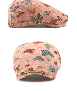 Detail of pink jacquard beret featuring colorful butterfly patterns and metal side buckle