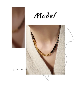 Close-up of gold twist chain necklace with black agate beads and OT toggle clasp on model
