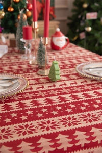 Detailed view of red and beige Christmas tablecloth featuring festive reindeer and snowflakes