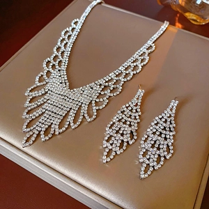 Macro detail of luxury rhinestone lace necklace and earrings set on a beige display stand