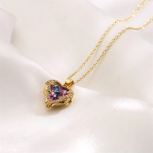 Macro view of gold heart pendant with purple zircon and diamonds on white silk background