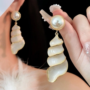 Vintage style seashell pearl drop earrings shown on model with retro gold accents