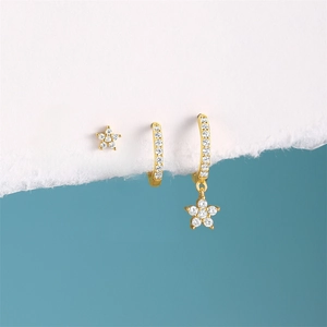 Detailed view of 3-piece gold S925 silver star earring set with zircon on blue background