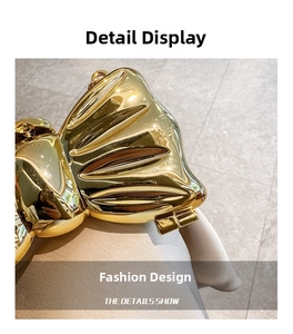 Detailed macro view of the polished golden metal bow buckle on the acrylic mini handbag