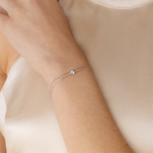 Detail showing elegant double-layer silver chain bracelet with round solitaire zircon