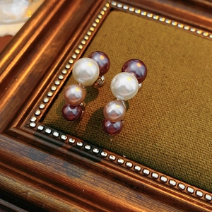 Vue rapprochée des boucles d'oreilles vintage avec dégradé de perles tricolores