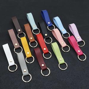 Set of 14 PU leather keychains with gold rings in diverse colors on a dark background