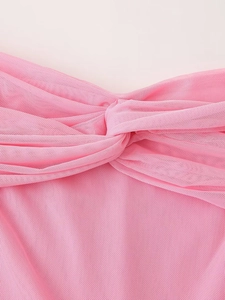 Detailed close-up of pink mesh dress featuring an elegant twist knot on the chest area