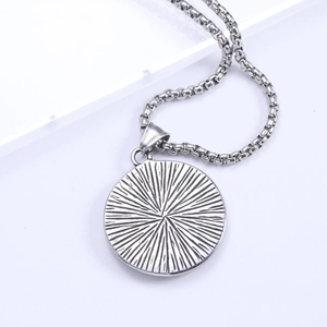 Macro view of vintage stainless steel round wolf head pendant with sunburst texture