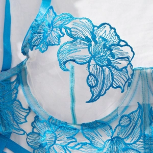 Close-up of light blue floral lace embroidery on sheer mesh bra with delicate details