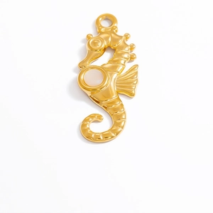 Close-up of a 18k gold-plated seahorse pendant with a white pearl inlay detail