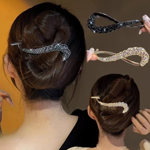 Detail of twisted metal hair clip with sparkling rhinestones in dark grey and champagne gold