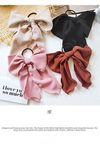 Detailed view of large chiffon bow hair ties in beige pink red and black colors