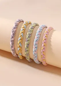 Detail of colorful woven elastic hair ties set wrapped on a beige cylinder display