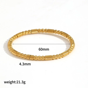 Bamboo-textured gold titanium steel bangle shown from above on a clean white background