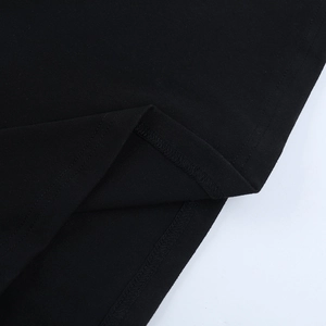 Detailed close-up of double-needle stitching and hemline finish on black knit dress