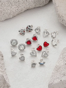 Macro view of S925 silver MOM heart earrings set with sparkling zircon on stone surface