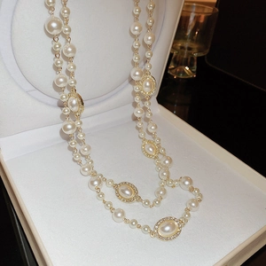 Close-up of elegant multi-layered pearl necklace with crystal gold accents in a jewelry box