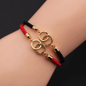 Detail of woven rope bracelets with interlocking gold-plated rings and colorful zircons