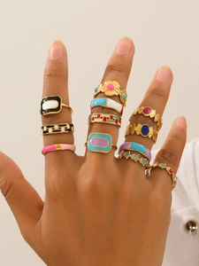 Close-up of hand wearing 18k gold plated rings with colorful enamel flower patterns