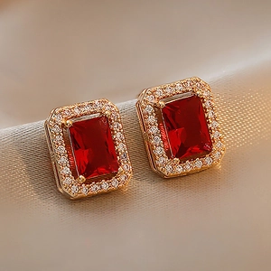 Vintage gold stud earrings featuring a rectangular red crystal and halo diamonds