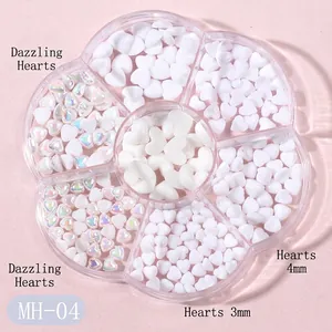 Close-up of iridescent and matte white heart nail charms in a flower storage box