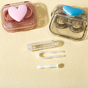 Pink and grey heart contact lens cases with tweezers, applicator and solution bottle